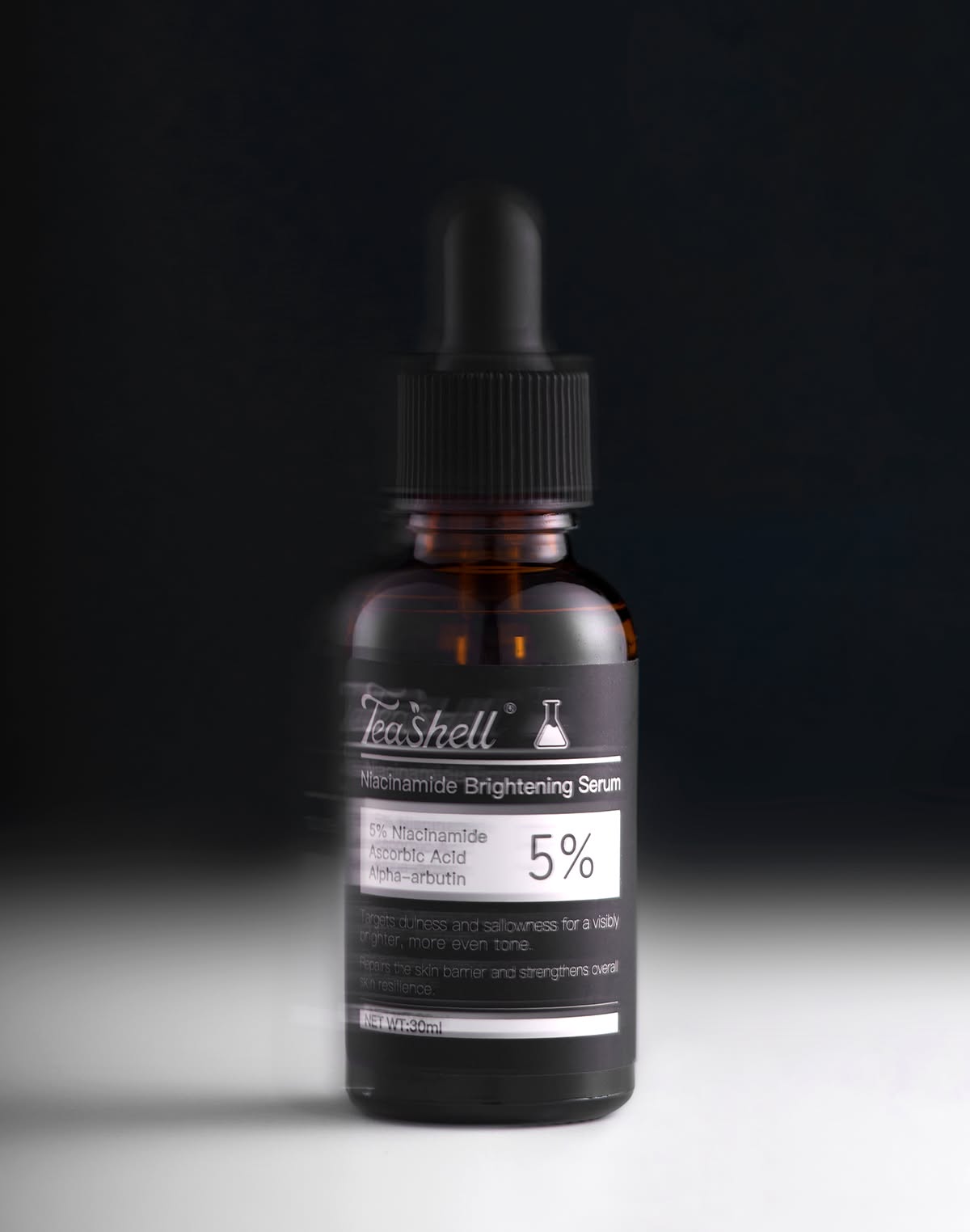 Teashell Niacinamide serum dropper bottle product shot black background